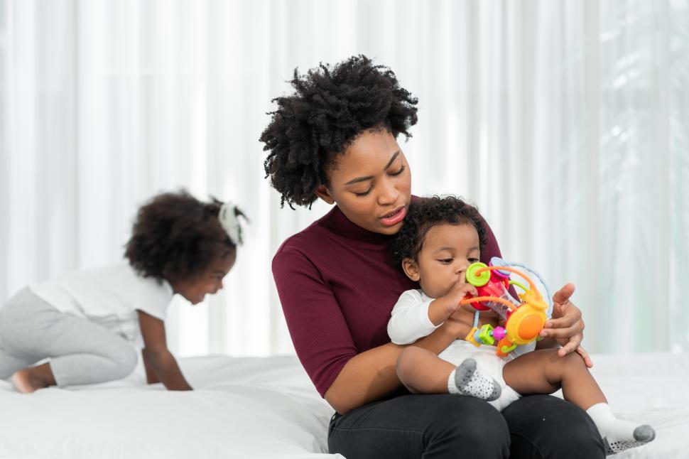 Free Image of A young African mother raises her children and plays with them 