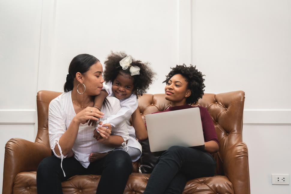 Free Image of Couple Playing with Child on the Couch 