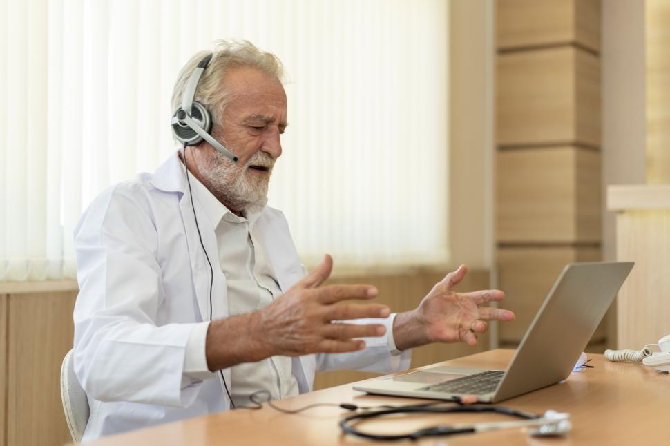 Free Image of Senior doctor wears headset. Remote online medical consultation 