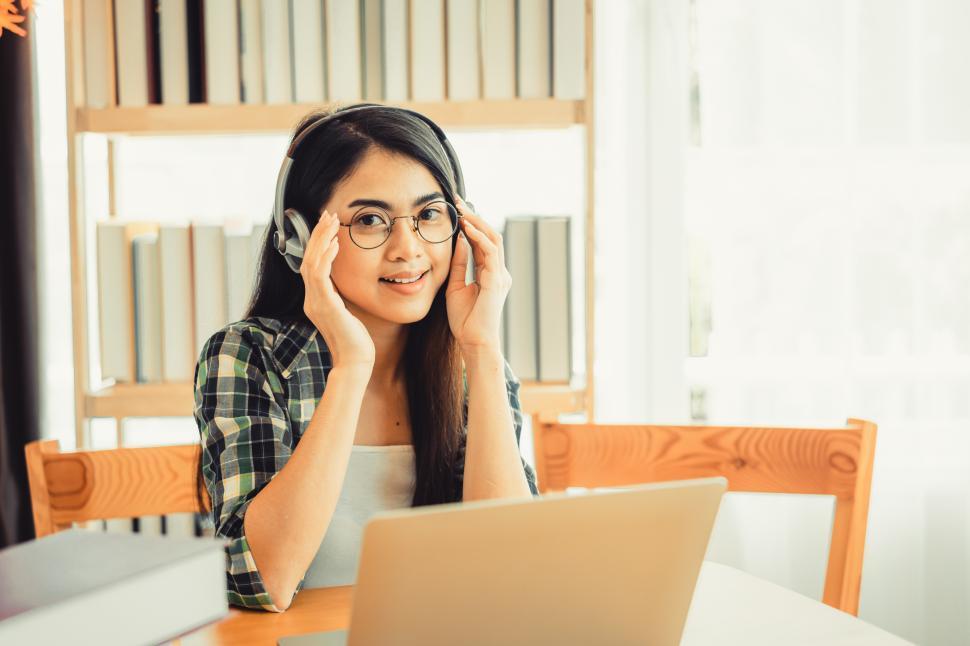 Free Image of Young female student in plaid shirt sitting at the table 