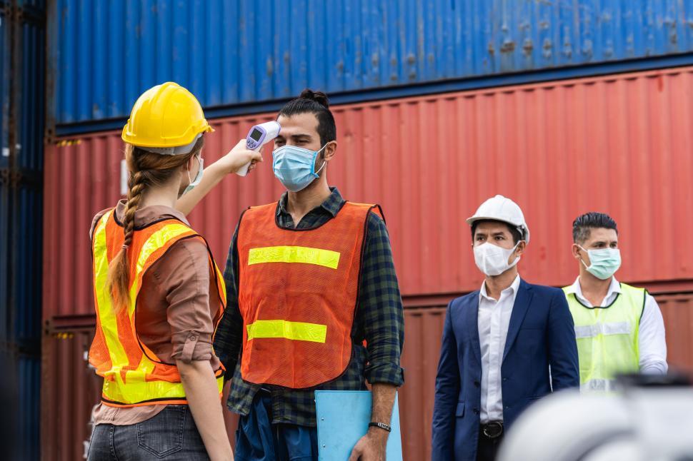 Free Image of Engineer worker wearing surgical mask checking body temperature 