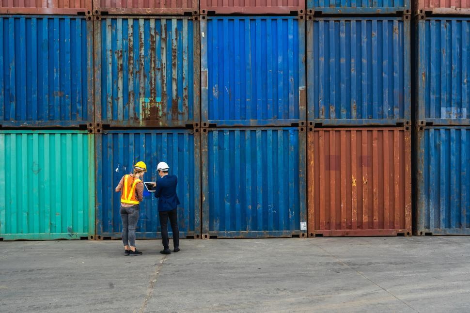 Free Image of Workers hold a laptop, document for checking shipment containers 
