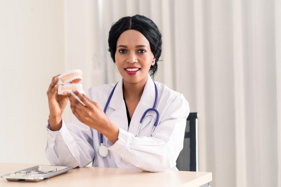 Free Image of Young female dentist holding dentures 