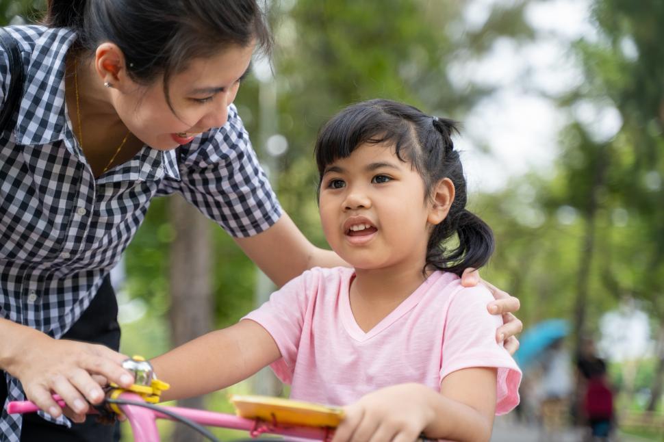 Free Image of happy young mother and daughter riding a bike 