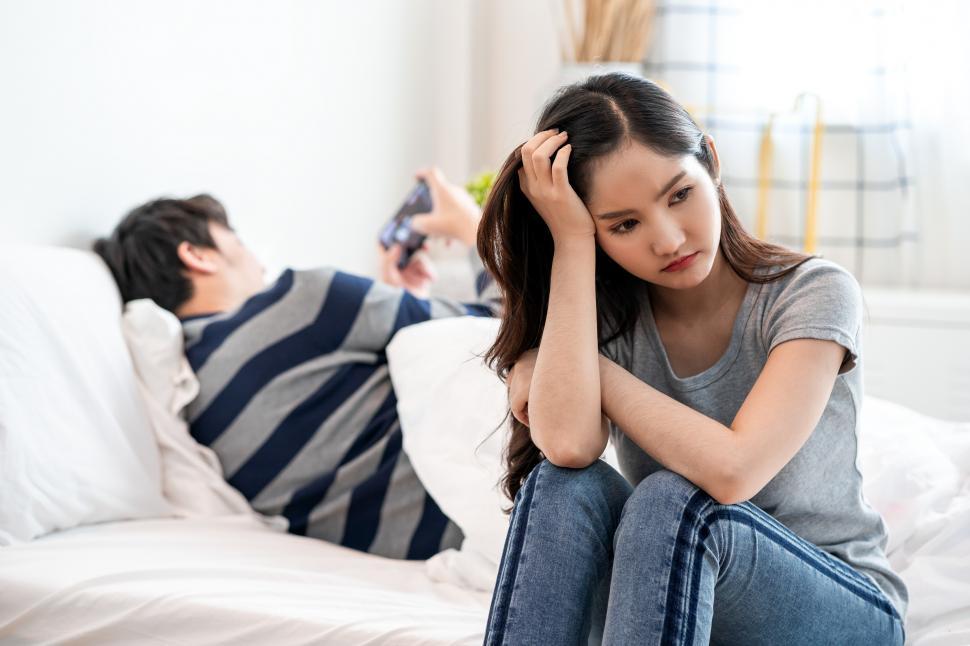 Free Image of Young upset woman sitting on the bed 