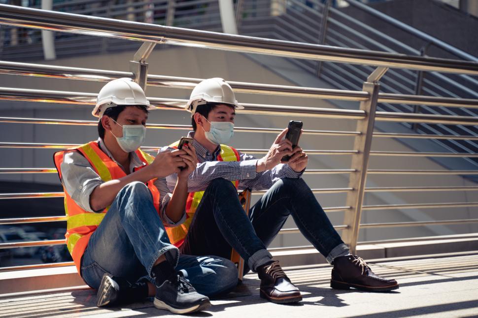 Free Image of Construction workers waring surgical mask and safety gear 