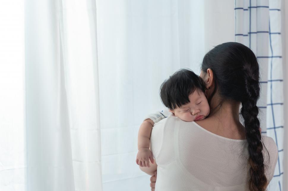Free Image of Mother Cuddling Sleeping Baby Daughter  