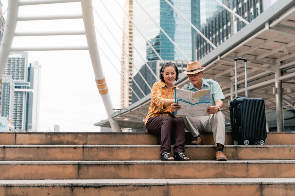 Free Image of A couple of elderly Asian tourists looking at the map 