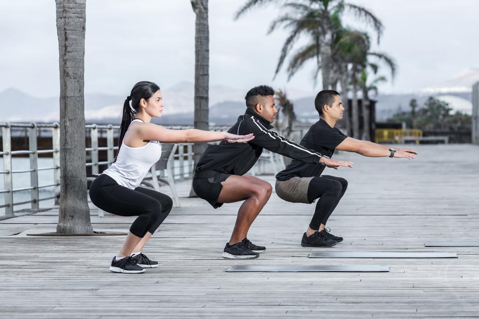 Free Image of Athletes squatting on embankment 
