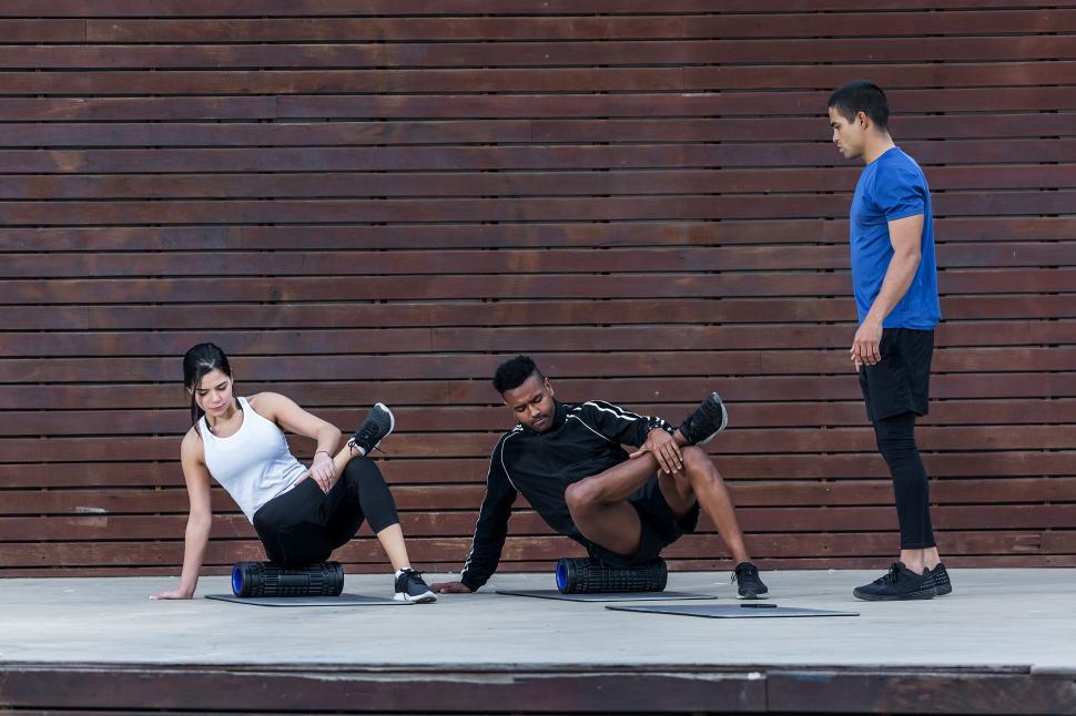 Free Image of Trainer looking at athletes exercising on roller 