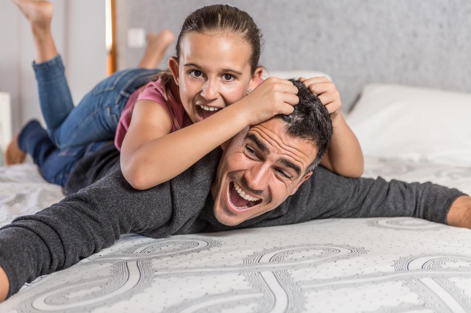 Free Image of father playing with his daughter on bed 