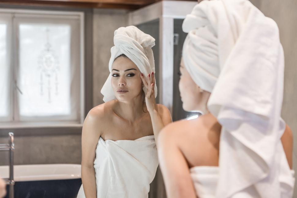 Free Image of Woman applying cream after shower 