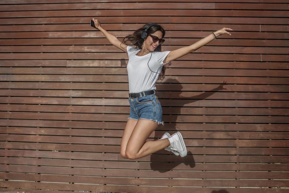Free Image of Energetic woman jumping against wall 