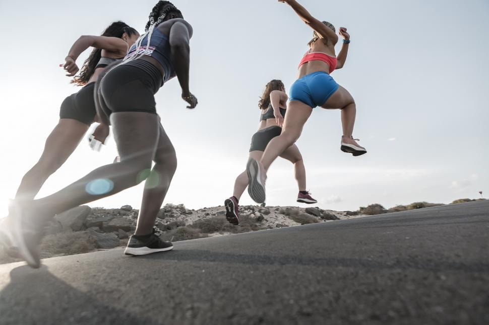 Free Image of Anonymous diverse female athletes sprinting during dusk 