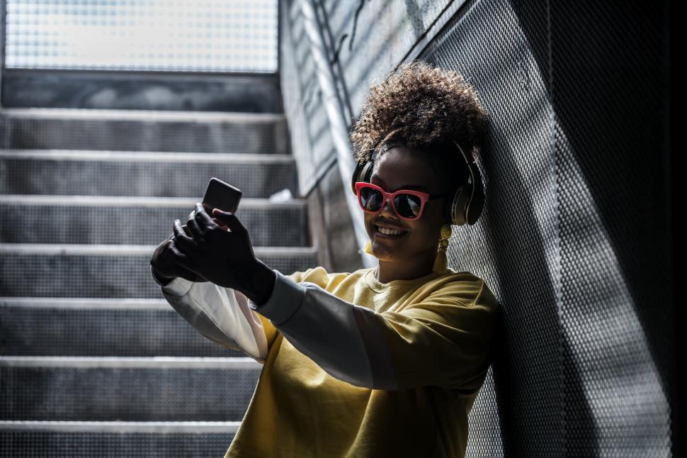 Free Image of Cheerful stylish woman taking selfie on stairway 