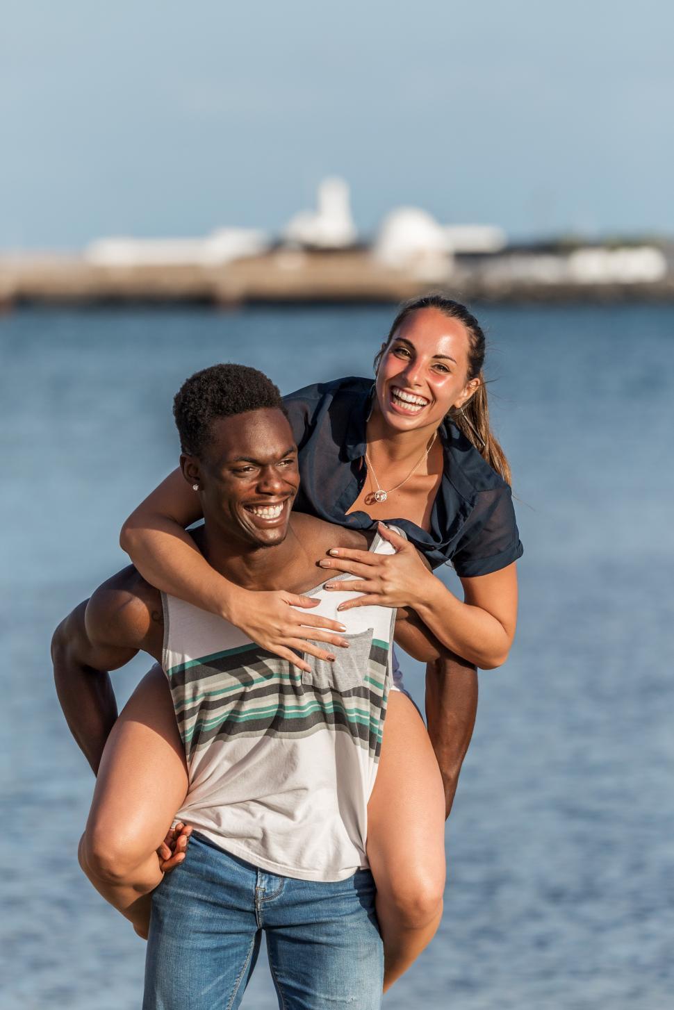 Free Image of Excited biracial couple having fun near sea 