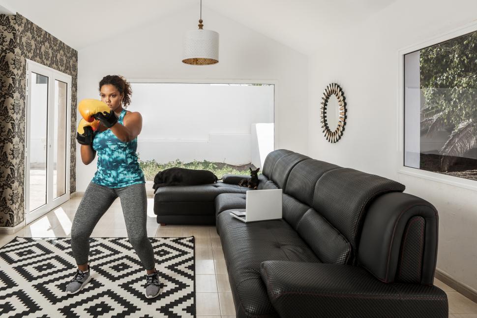 Free Image of Determined woman training in boxing gloves at home 