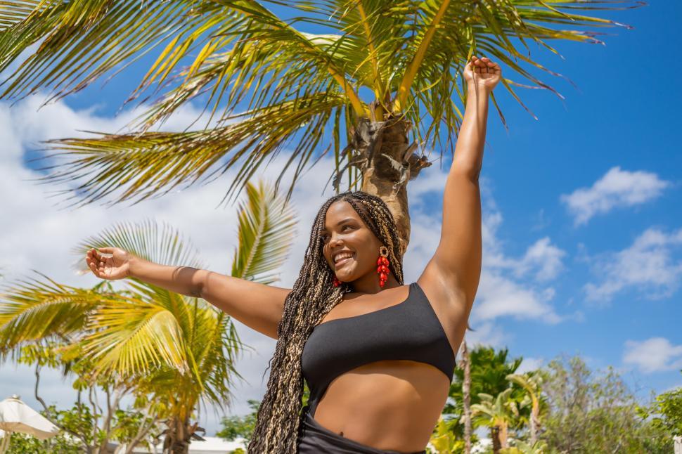 Free Image of Happy African American woman in summer clothes with arms outstretched 