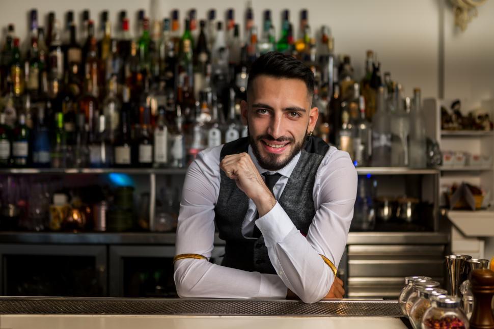Free Image of Smiling barman standing at bar counter 