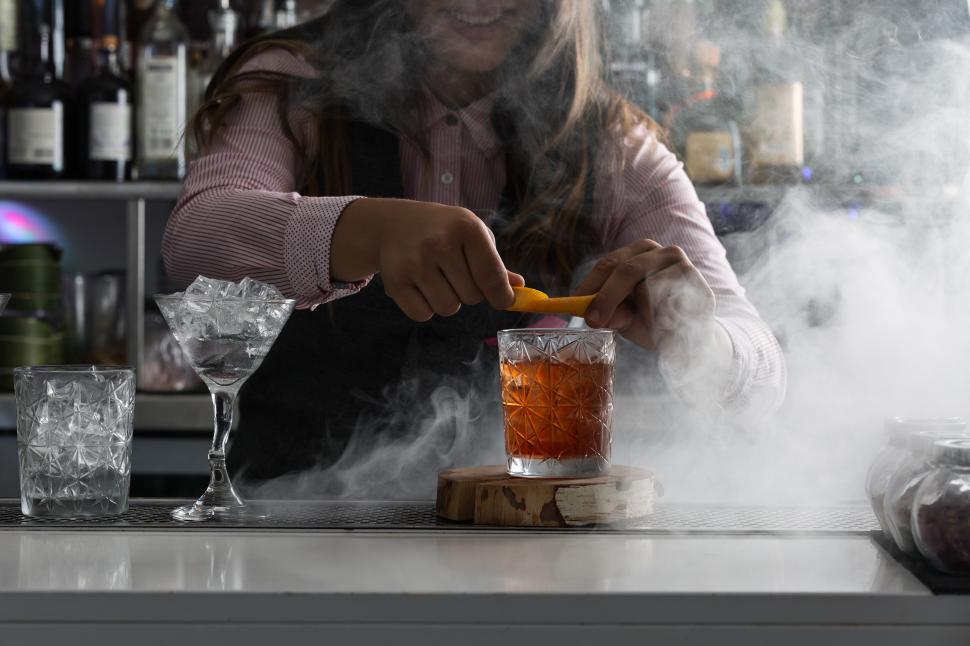 Free Image of Barkeeper serving cocktail at bar counter 