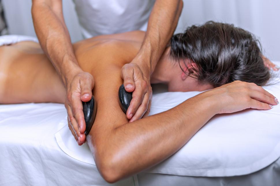Free Image of Side view of young woman having arm massage with stones 