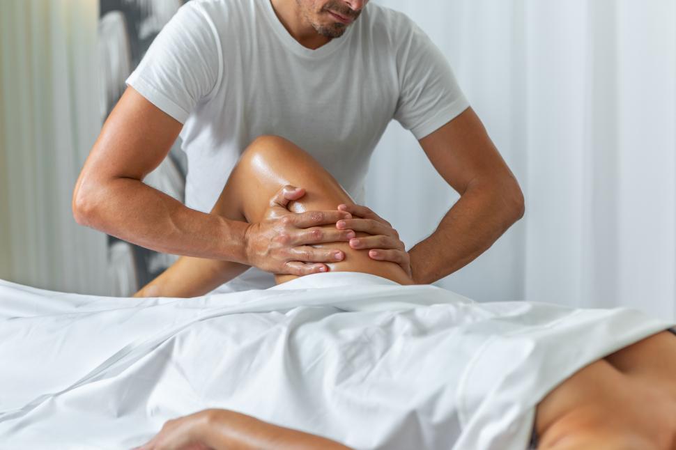 Free Image of Close up view of a male masseuse doing a leg massage 