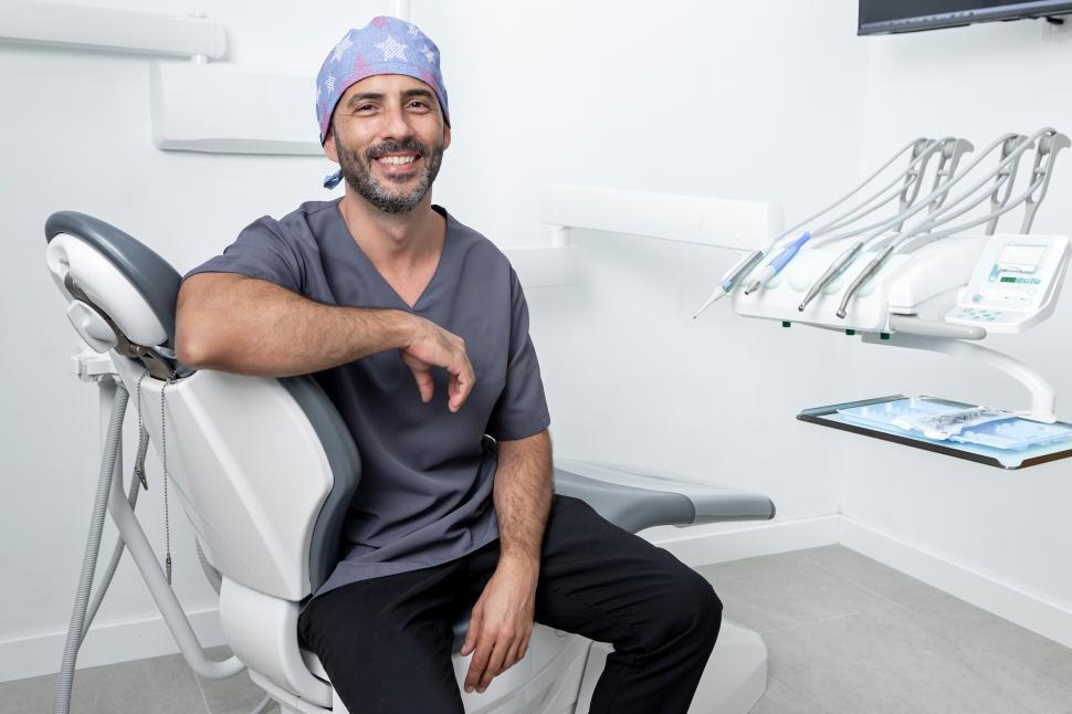 Free Image of Dentist leaning on an exam chair in a dental clinic 