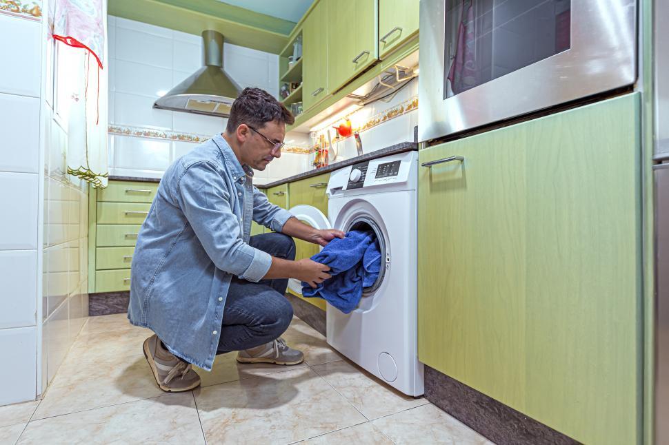 Free Image of adult man loading the washing machine 