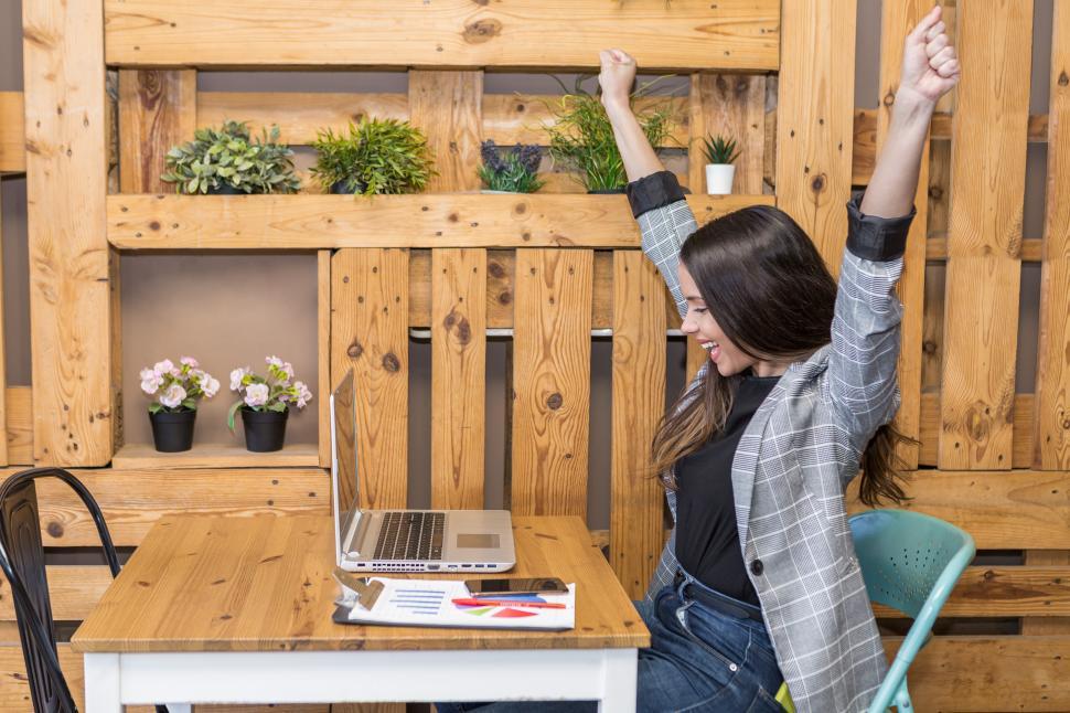 Free Image of Happy woman with raised fists during remote job 