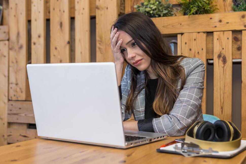 Free Image of Tired freelancer reading bad report on laptop during online work 