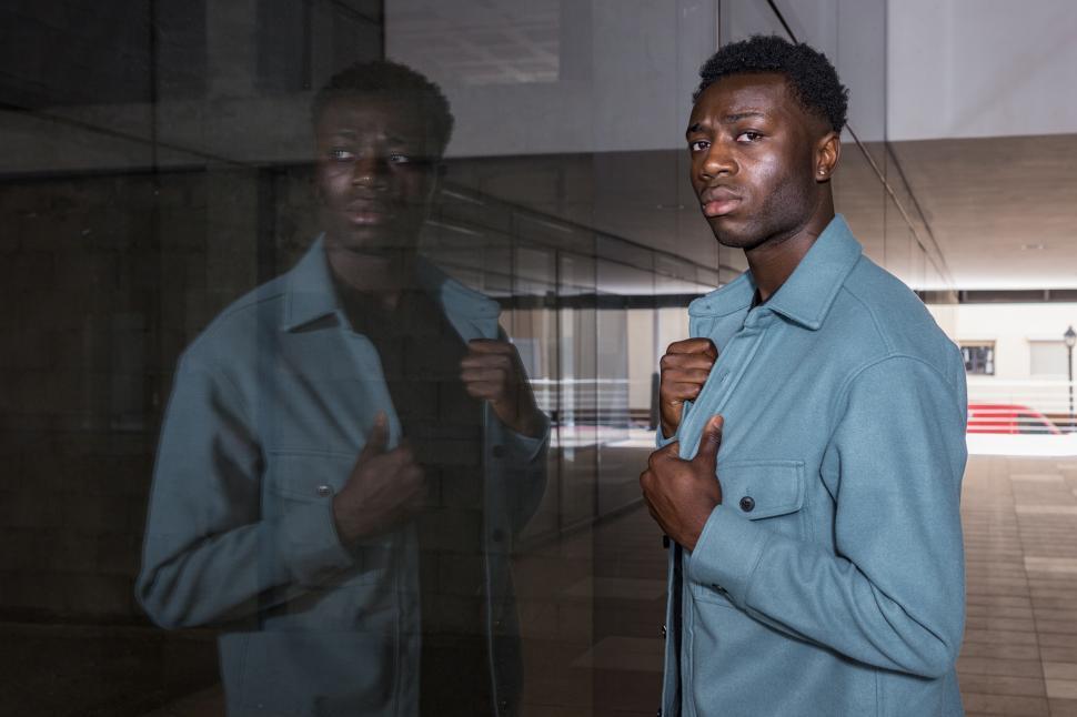 Free Image of Confident stylish African American guy adjusting trendy jacket i 