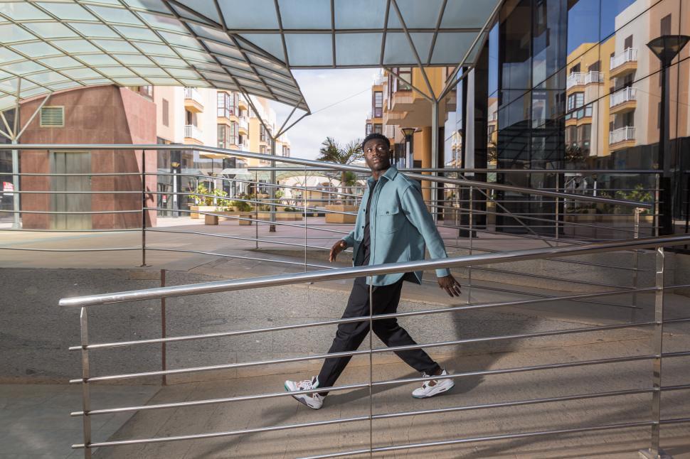 Free Image of Cool African American guy walking near contemporary building 