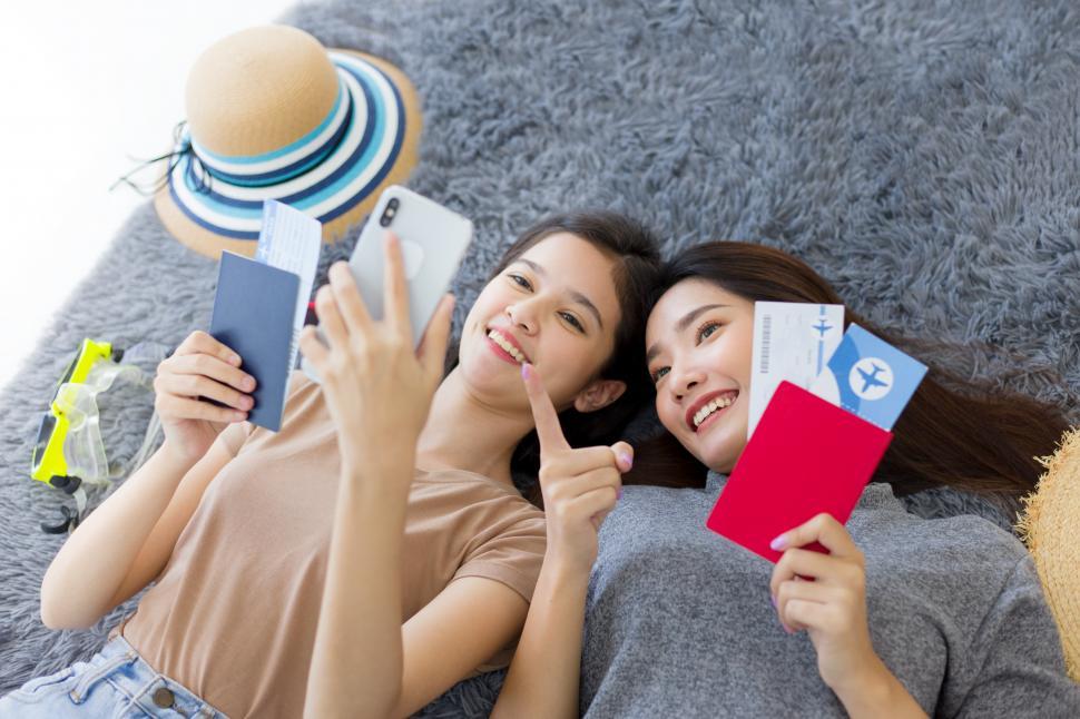 Free Image of Two Asian women planning a summer vacation trip. 