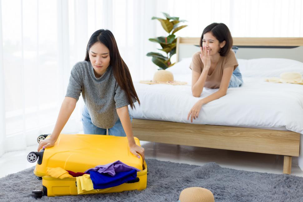 Free Image of Young woman packing travel suitcase. 