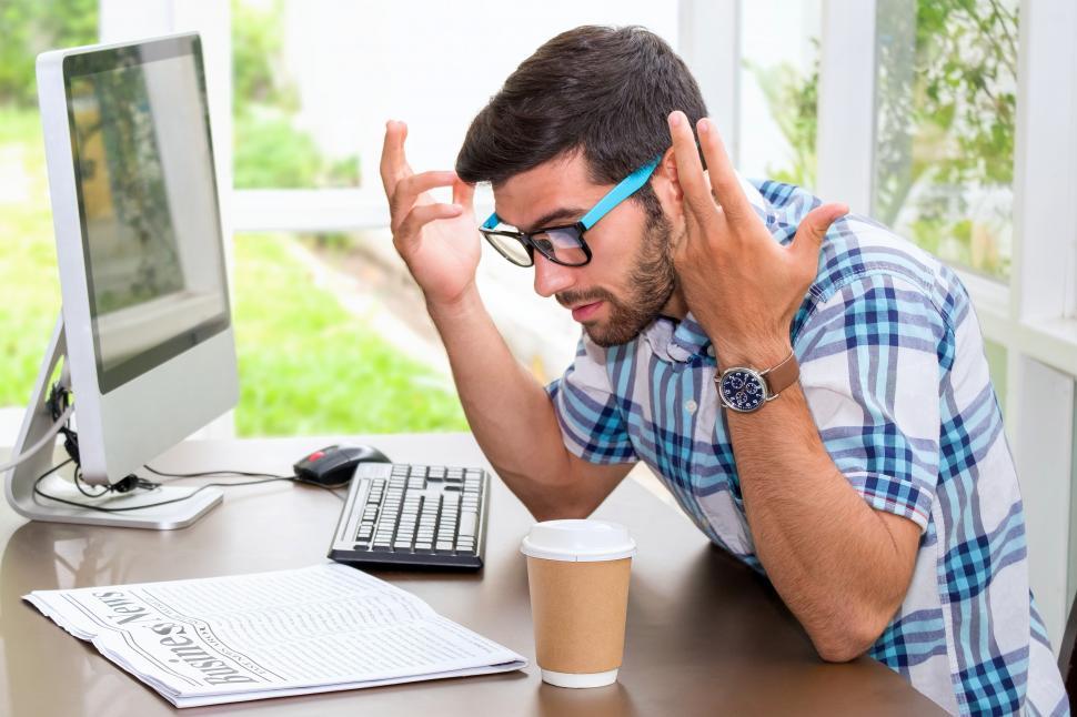 Free Image of Businessman is feeling in shock when reading the morning news. 