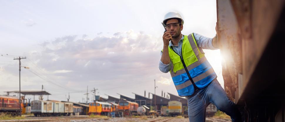 Free Image of Railway engineer holding a walkie-talkie on the train. 