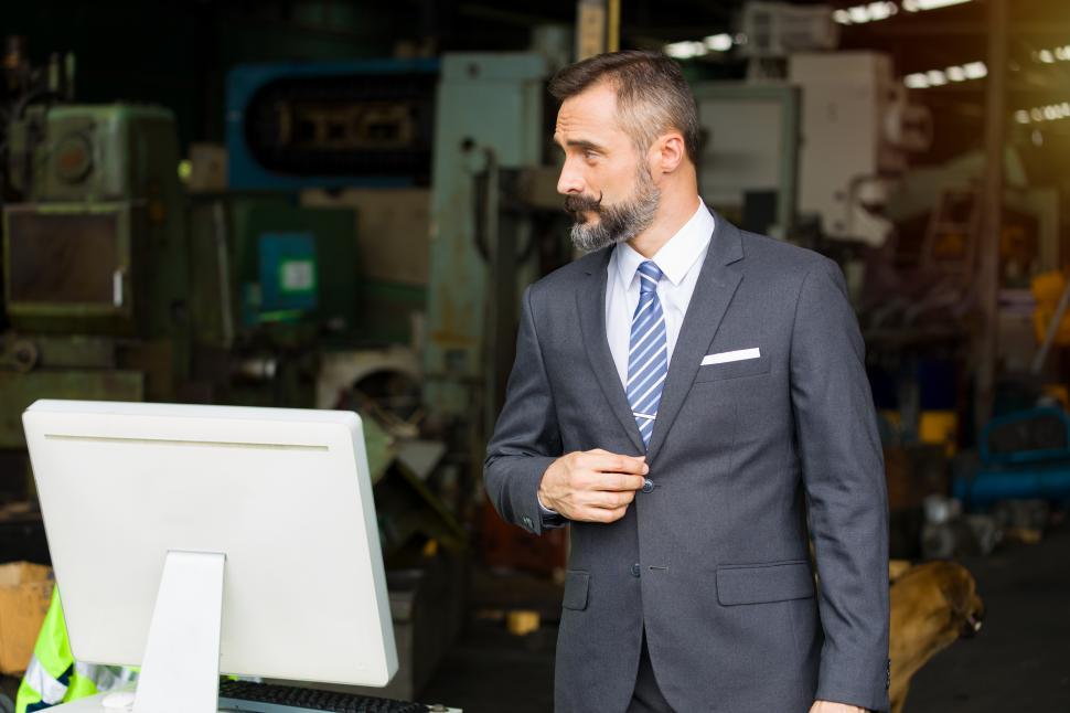 Free Image of Factory manager stands in front of the warehouse. 