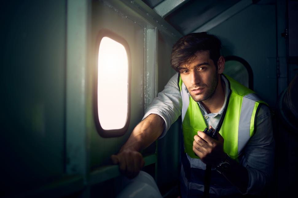 Free Image of A male engineer holding a walkie-talkie in the control room 