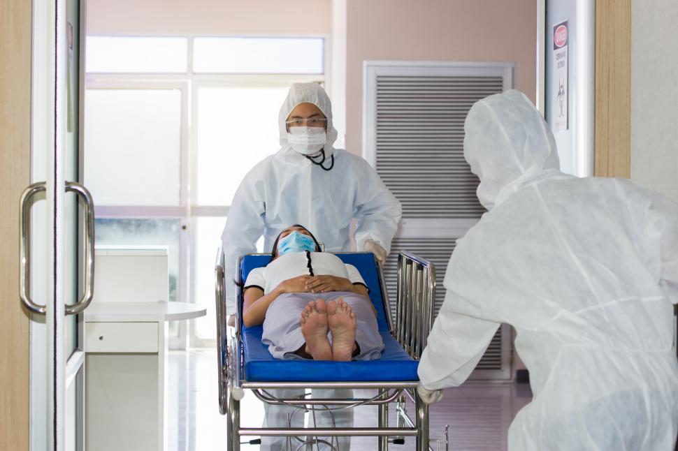 Free Image of Medical staff pushing a patient gurney of a severely ill into the emergency room 
