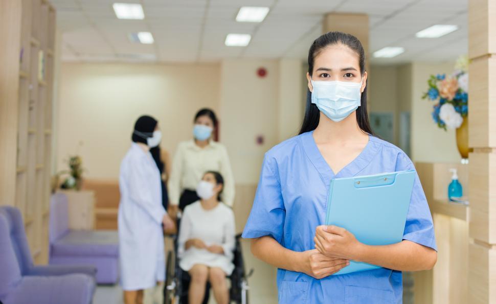 Free Image of Doctor wearing a mask holding a file in the hospital 
