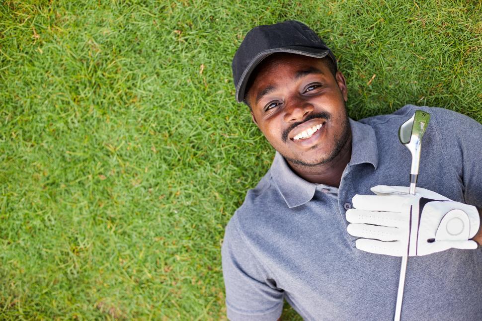 Free Image of Golfer laying on the grass, looking up 