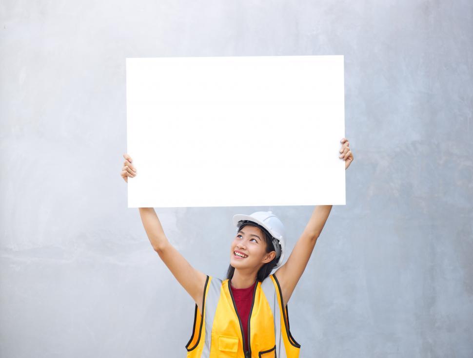 Free Image of A female engineer holding a paper placard with empty space with 