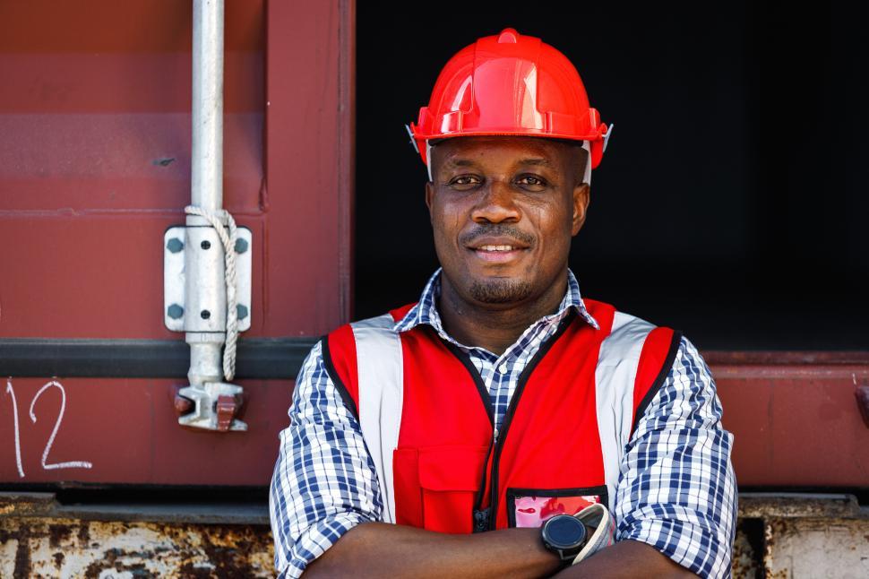 Free Image of Industrial worker in protective clothing stands with arms crossed 