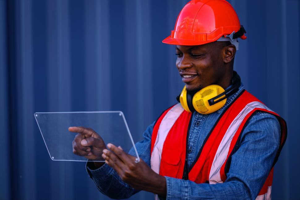 Free Image of Engineer holds a clear plastic rectangle like a tablet  