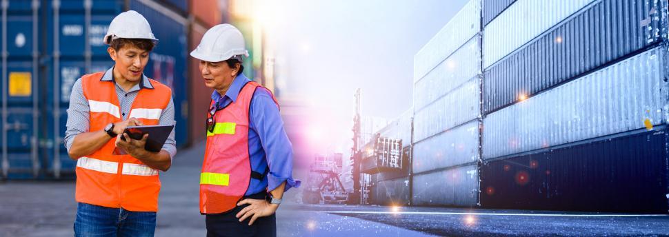Free Image of Two male engineers work in a commercial port container yard 