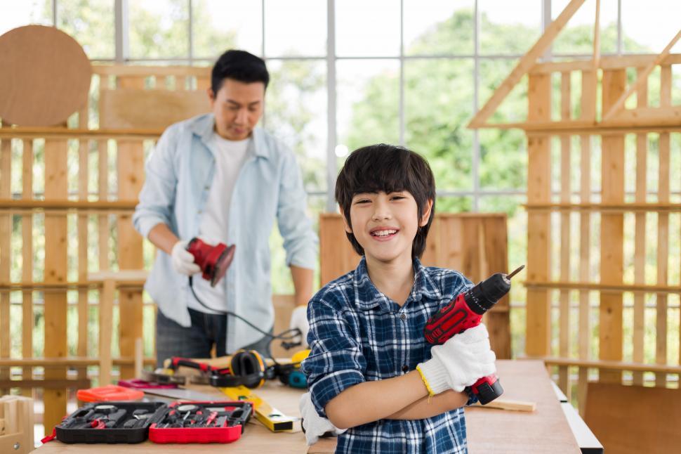 Free Image of A lovely son helps his father do carpentry at home. 