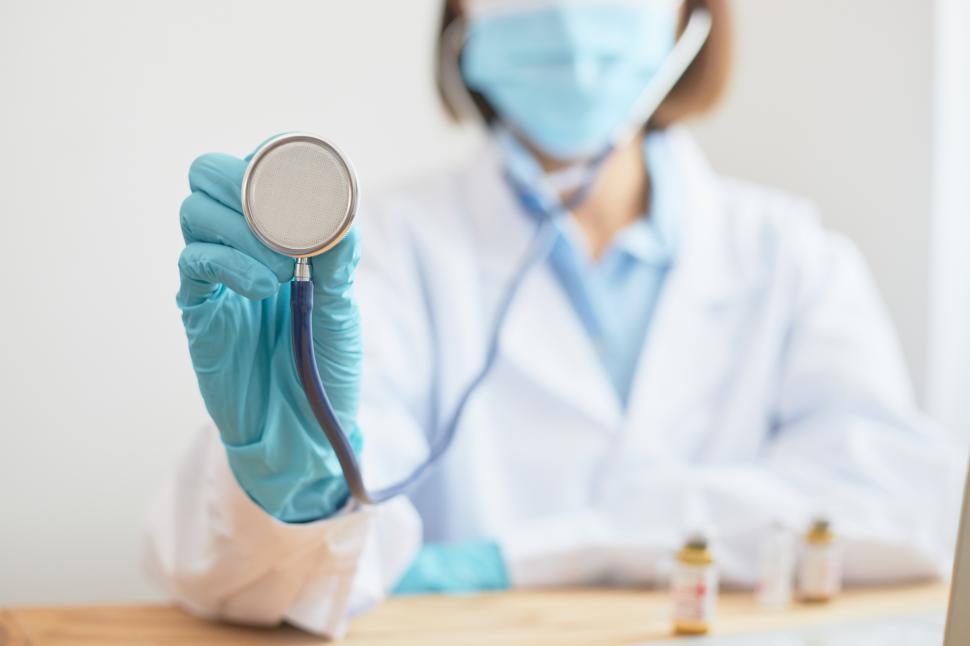Free Image of A female doctor holds up a stethoscope  