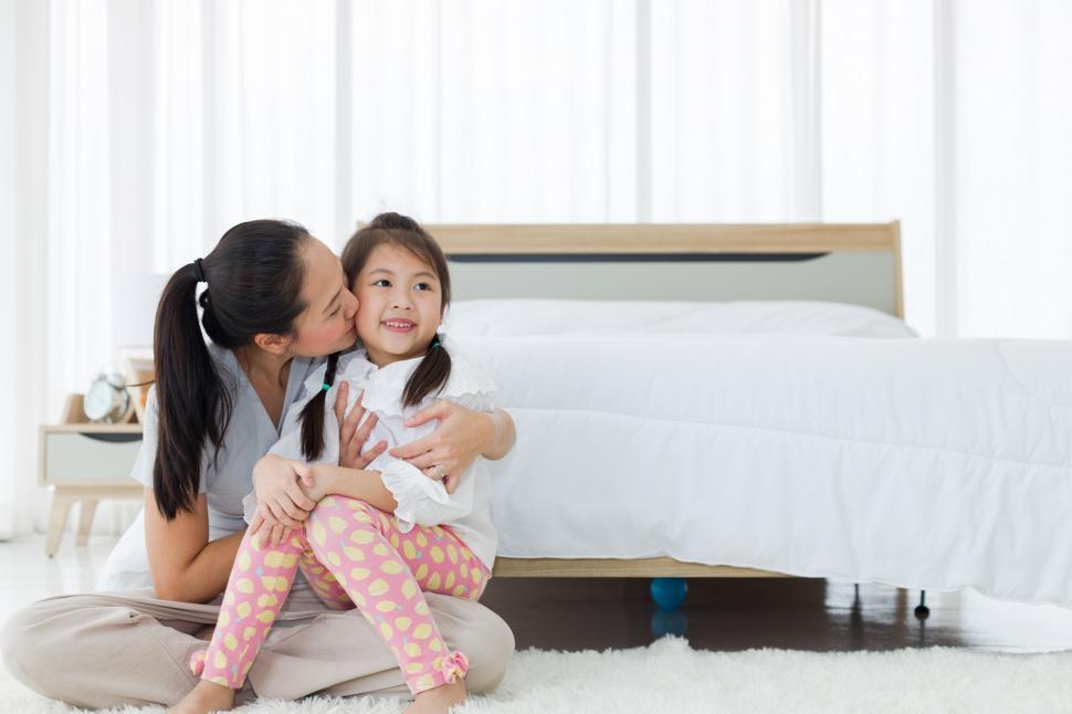 Free Image of Mother hugs her daughter in the bedroom 
