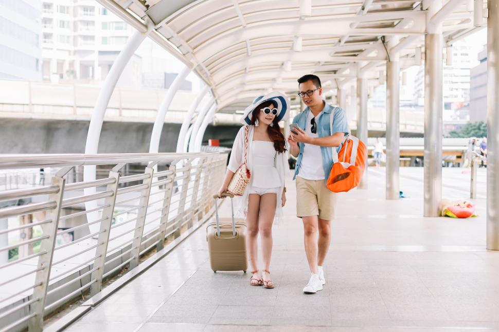 Free Image of Tourists holding a phone to search the map 