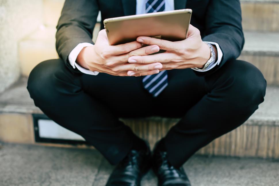 Free Image of Businessmen sit on the stairs with tablet device 